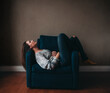 © Cavan Images - Attractive woman resting in a comfortable chair in an empty room.