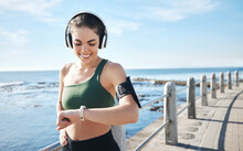 Headphones, Smartwatch And Woman Running For Workout, Exercise And Health Results, Progress Or Fitness Steps. Goals, Check Timer And Sports Person At Beach Listening To Music Or Podcast For Training
