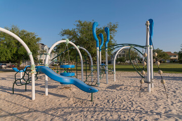 Wall Mural - Playground on a sand near the residential homes at Navarre, Florida. There are playground equipment at the front of the houses with large field with trees.