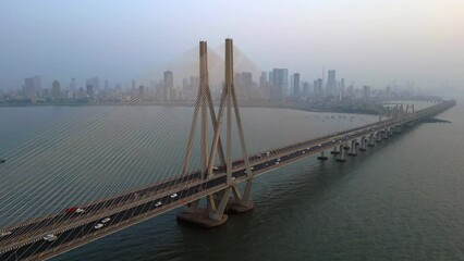 Wall Mural - Aerial view of traffic on the Bandra Worli Sea Link cable stayed bridge with the Mumbai skyline in the background in Mumbai, Maharashtra, India.