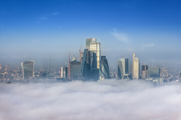 Wall Mural - The modern skyline of the City of London peaking out of the fog on a cold winter day, England