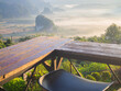 Brown wooden table or terrace corner and black chair in cafe or restaurant with blurry panoramic hill, mountain and fog in the morning landscape and nature background