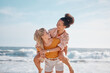 © Lumeez/peopleimages.com - Piggyback, ocean and happy couple of friends for lgbtq, lesbian or love and freedom on summer vacation together. Blue sky, beach and diversity women on date, fun support or excited valentines holiday
