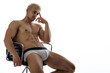 Sexy blond man in underwear. Muscled male model thinking and sitting on chair. 