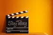 © noppadon - Story telling text title on film slate. Film clapper board or movie clapper cinema board , Slate film on black wooden with orange wall background .cinema concept