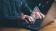 © Looker_Studio - user is using computer with triangle caution warning sign for notification error and maintenance concept. hacker attacks and hacking data, cyber crime, cyber security, Ransomware, Phishing, Spyware.