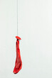 © Serhii - Deflated red balloon. Hanging on a black thread.