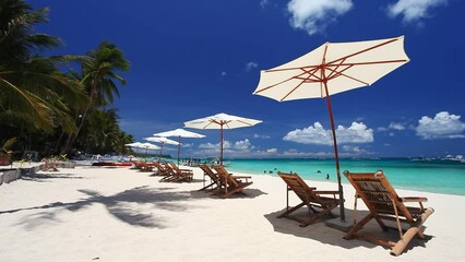 Poster - Sun umbrellas and beach chairs on tropical beach with palm trees. Summer vacation. Boracay