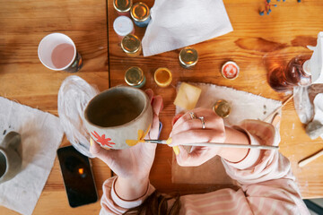 A female potter paints a ceramic mug. The process of creating clay products