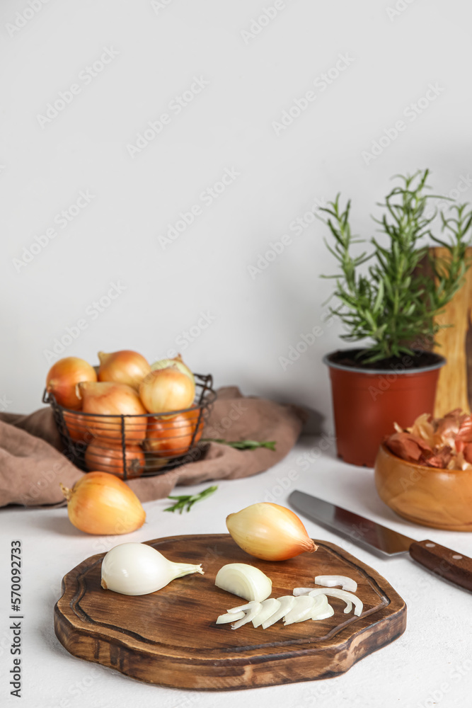 Wooden board with cut onion on light table