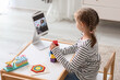 Little girl with cubes having online psychologist session at home