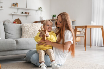 Wall Mural - Mother and her little son with wooden toys at home