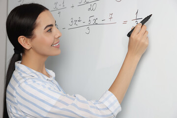 Wall Mural - Happy teacher explaining mathematics at whiteboard in classroom