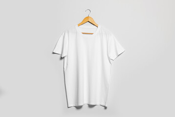 Wall Mural - Hanger with white t-shirt on light wall. Mockup for design