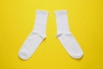 Poster - Pair of white socks on yellow background, flat lay