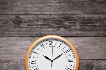 Wall Mural - Stylish round clock on wooden table, top view with space for text. Interior element