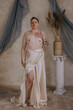 non-binary person standing shirtless with hand on heart wearing white fabric eyes closed