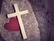Wooden cross with red heart shaped in retro background. Christianity concept.