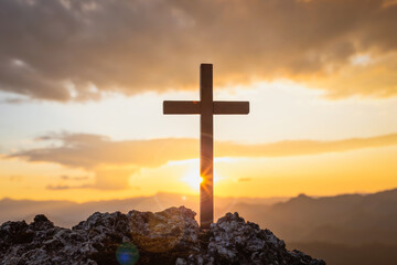 Wall Mural - Silhouettes of crucifix symbol on top mountain with bright sunbeam on the colorful sky background