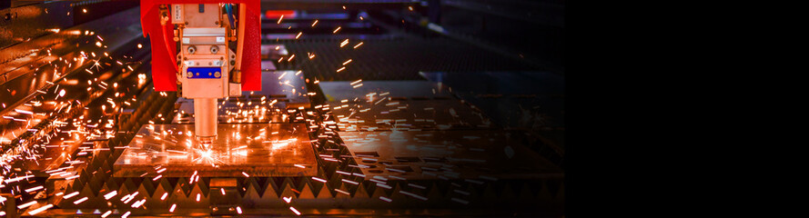 Wall Mural - industrial laser cut machine while cutting the sheet metal with the sparking light.copy space