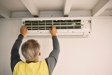 Poster - Construction, installation and back of a man with an air conditioner, maintenance and ac repair. Building, service and a handyman fitting a tool on a wall of a home for home improvement and heat