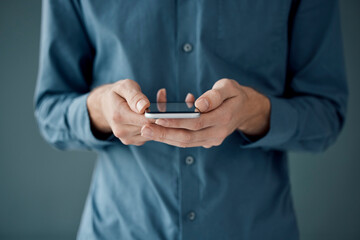 Poster - Hands, phone and networking for social media, communication or digital marketing against a studio background. Hand of person holding mobile smartphone for online chatting, conversation or app