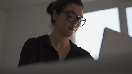 Young concentrated woman it specialist entering data to script program and waiting for final result of checkout, working on application interface development