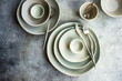 Cutlery and dinnerware set on concrete background