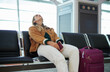 © Nina L/peopleimages.com - Bored woman, airport and luggage waiting with passport for missed flight, travel or vacation journey in Cape Town. Female traveler sitting in wait for delay departure, boarding plane or immigration