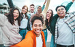 © Davide Angelini - Multi ethnic guys and girls taking selfie pic outdoors with smart mobile phone device - Multiracial community of young people smiling together at camera - Life style concept with teenagers hanging out