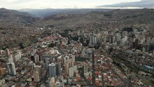 Aerial Drone Fly Above La Paz, Bolivia, Stadium Hernando Siles, Crowder Metropolitan City, Houses, Skyscrapers And Andean Cordillera Mountain Range In The Background