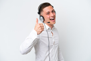 Wall Mural - Telemarketer Brazilian man working with a headset isolated on white background with thumbs up because something good has happened