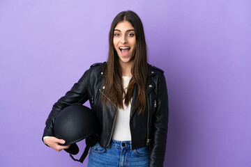 Wall Mural - Young caucasian woman with a motorcycle helmet isolated on purple background with surprise facial expression