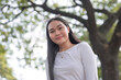 © Mdv Edwards - An Asian woman smiling for the camera for a low angle shot outside the garden.