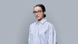 © Valerii Honcharuk - Smiling teenage female student looking at camera on gray background
