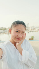 Poster - Young woman taking selfie on mobile phone on seascape background