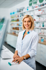 Wall Mural - Happy female pharmacist at work looking at camera.