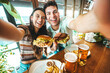 © Davide Angelini - Happy couple taking selfie with smart mobile phone at burger pub restaurant - Young people having lunch break at cafe bar venue - Life style concept with guy and girl hanging out on weekend day