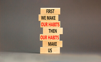 Our habits symbol. Concept words First we make our habits then our habits make us on wooden blocks. Beautiful grey table grey background. Copy space. Motivational business our habits concept.