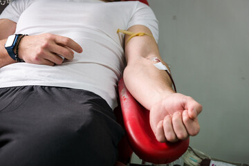 Detail with hand of a blood donor donating blood in a hospital
