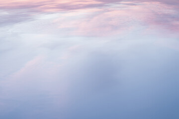 Wall Mural - Aerial view from plane on the sea through sky with soft and fluffy pastel pink and blue colored clouds. Sunset background. Nature. sunrise. Instagram toned style