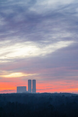 Canvas Print - clouds in dawn sky over city park and towers on cold morning