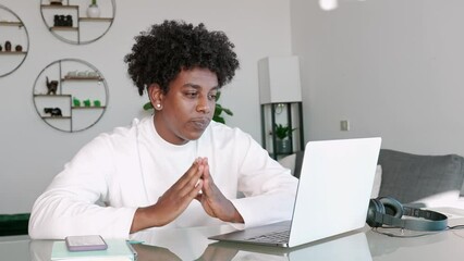 Wall Mural - African American hipster ethnic guy student using laptop talking to web cam learning english online on virtual elearning class or having hybrid video call job interview meeting sitting at home table.