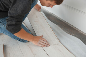 Sticker - Worker installing new laminate flooring in room, closeup