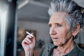 Poster - Thinking, nicotine and a senior woman smoking a cigarette in her home while looking out from a window. Idea, smoke and cancer with a mature female tobacco smoker in a house for pension or retirement