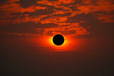 Fototapeta Kosmos - Total solar eclipse on the red orange sky in the morning