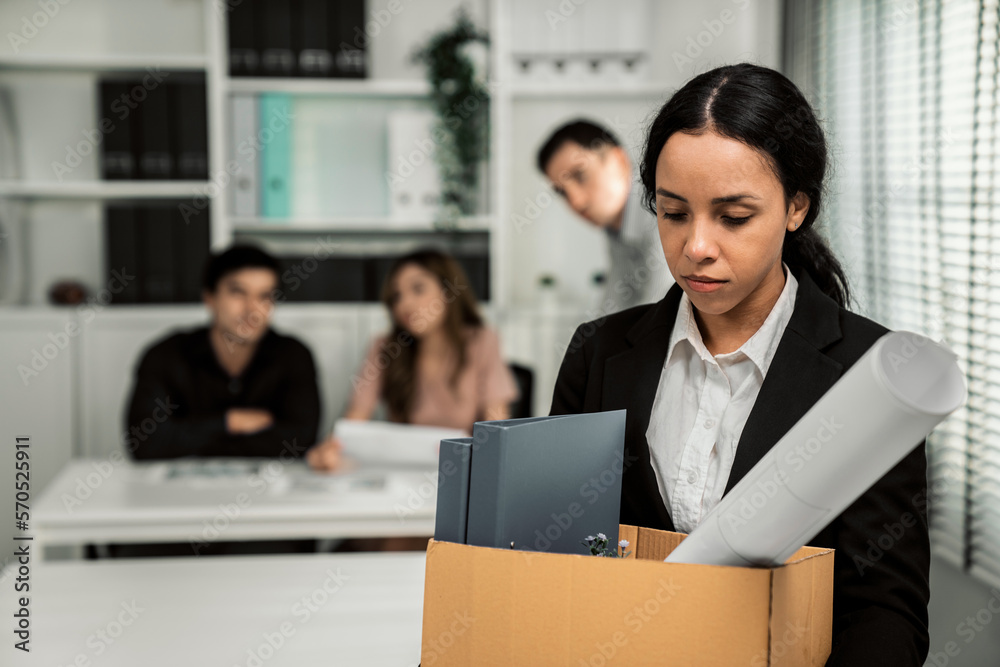 Depressed and disappointed employee packing her belongings after being ...