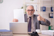 © Elnur - Old male employee working in the office