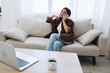 © SHOTPRIME STUDIO - Woman blogger with phone lying at home and talking on the phone on sofa with laptop and working freelancer online, smiling with teeth