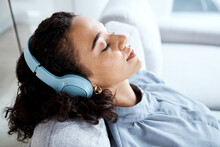 Face, Woman And Headphones For Listening To Music For Calm, Peace And Mindfulness On Home Couch. Young Person On Living Room Sofa Listen To Podcast, Audio Or Motivation To Relax Or Meditation Profile